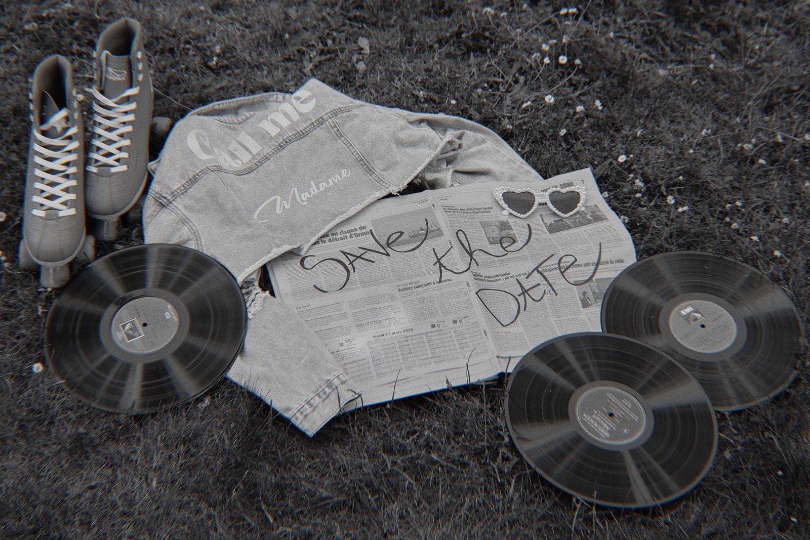 La veste brodée et le journal posés sur l’herbe, entre les vinyles.