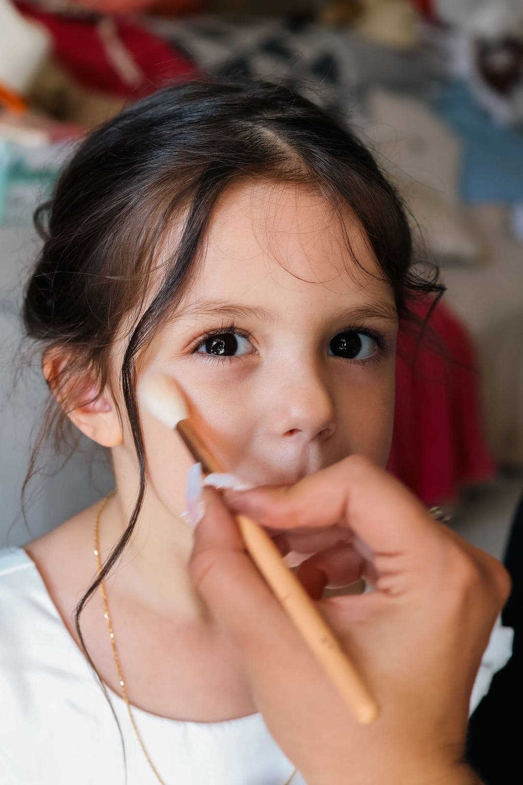 Une petite fille d’honneur se fait maquiller avant la cérémonie.