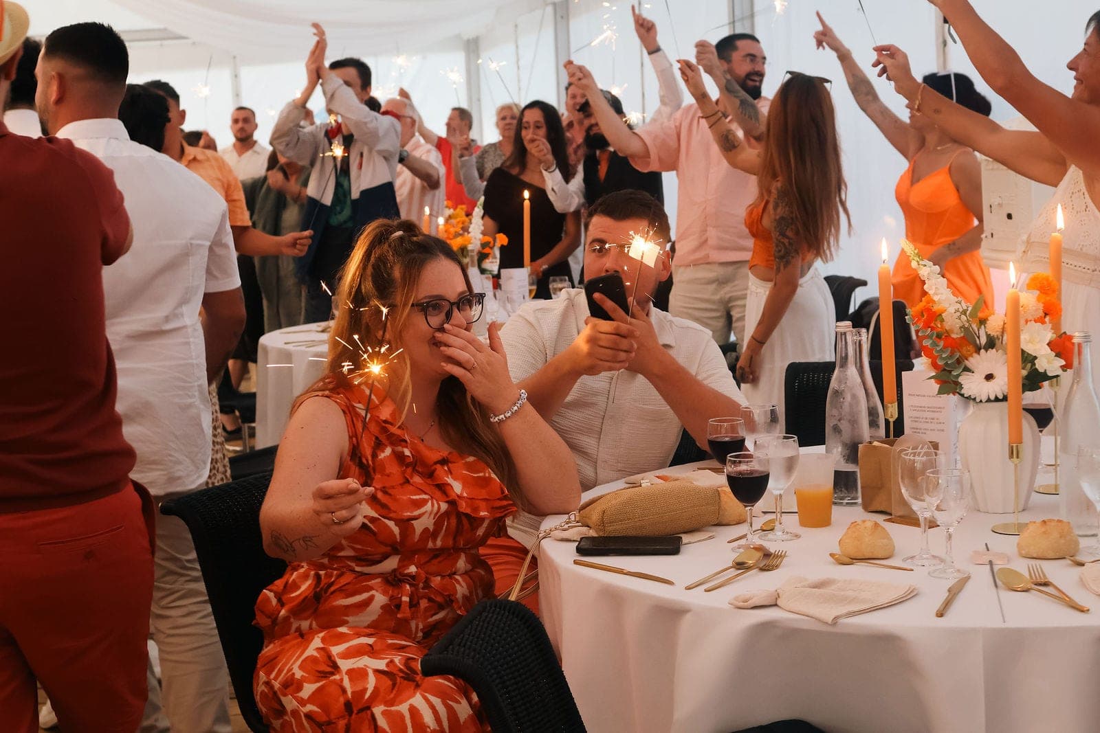 Les invités lèvent leurs cierges magiques autour de la table, au moment du dessert.