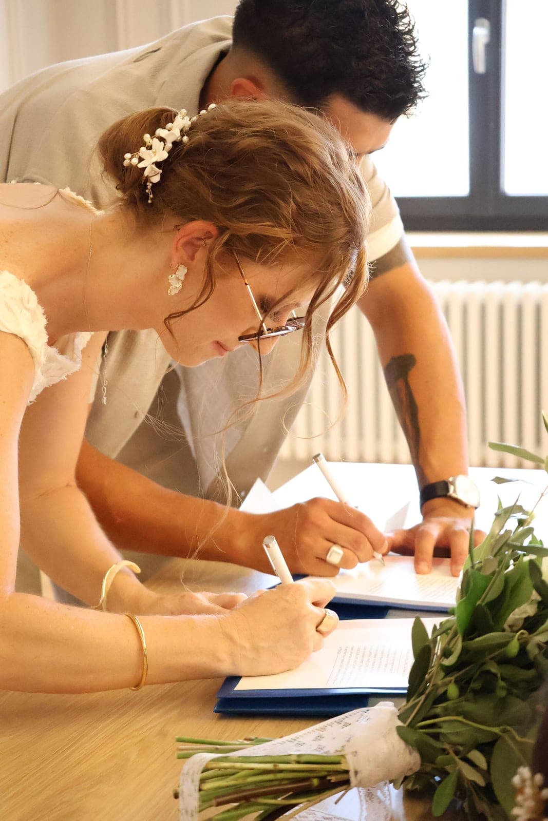 La signature du registre, en gros plan sur la main de la mariée.