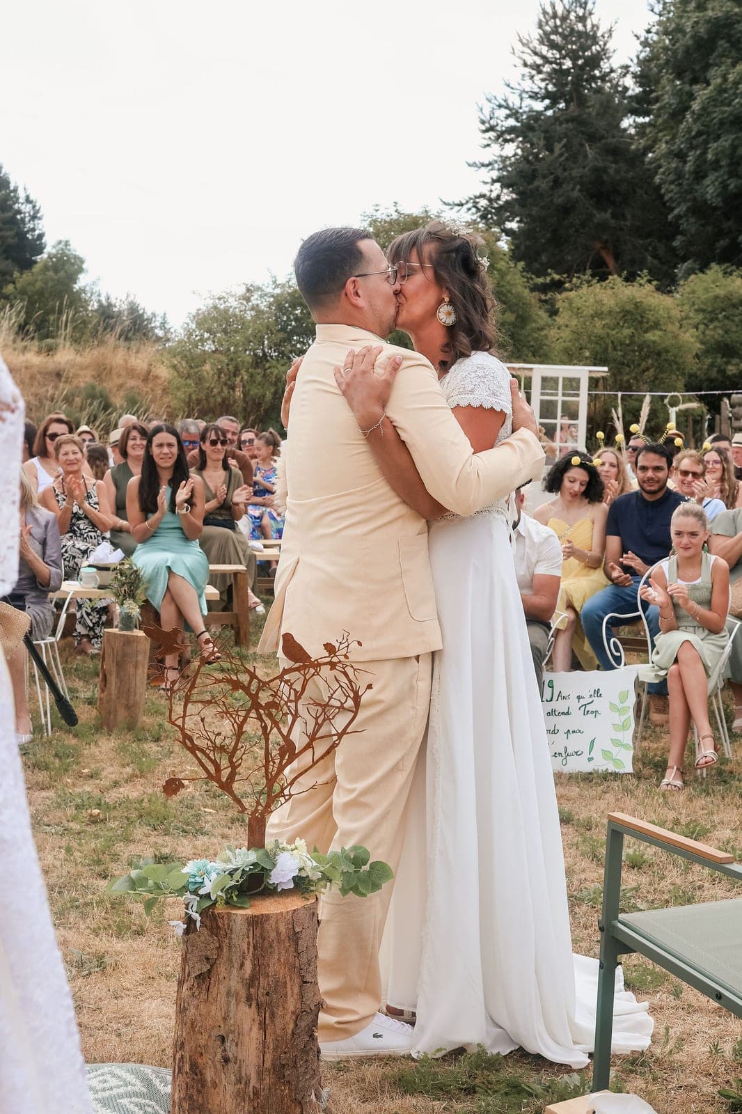 Une cérémonie laïque en plein air : le baiser des mariés devant les invités.