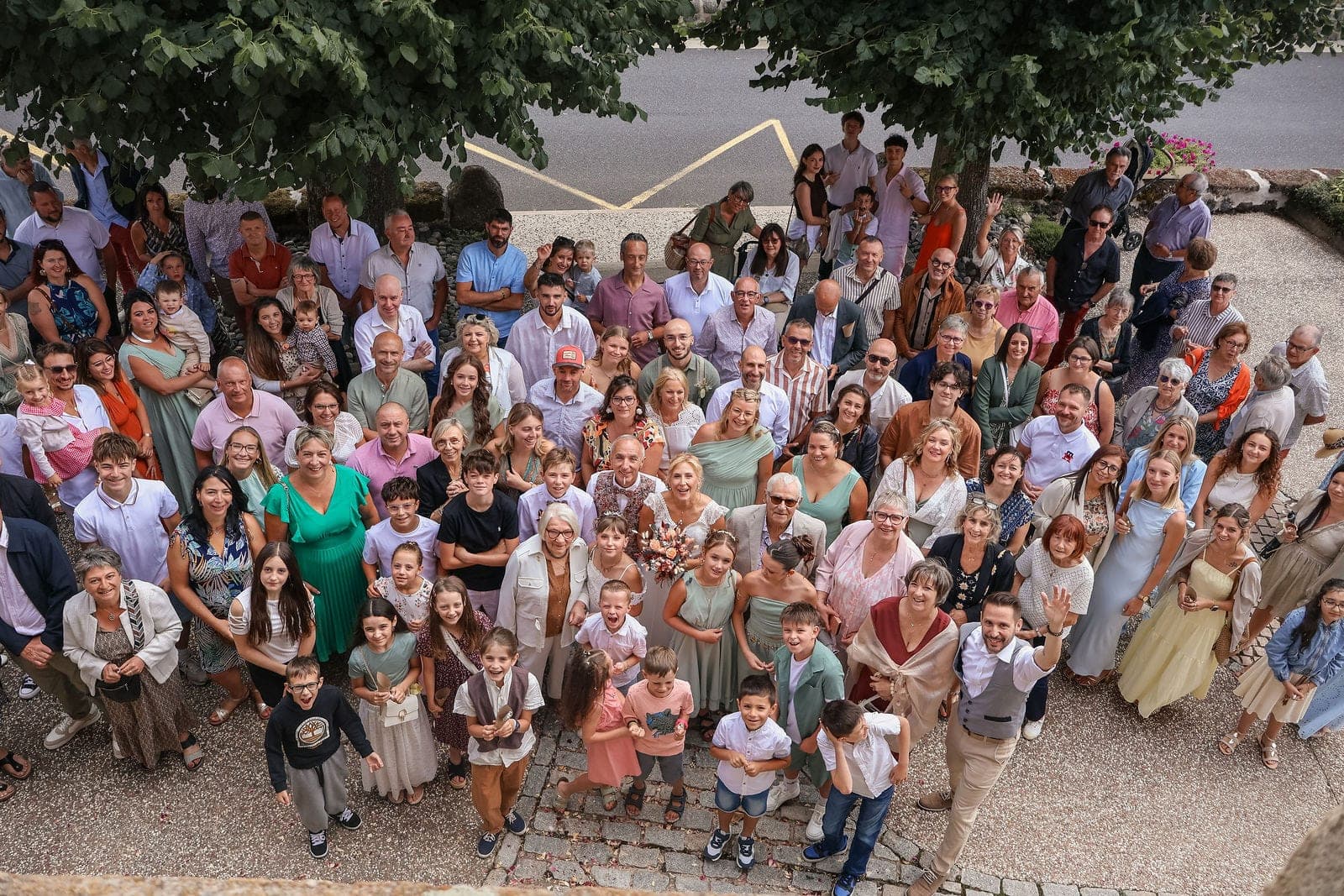 La photo de groupe vue de haut, tous les invités réunis sous les arbres.