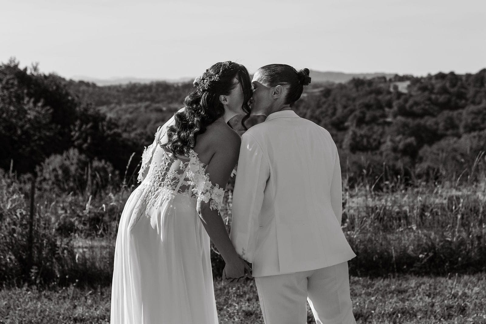 En noir et blanc, le couple front contre front dans les herbes hautes.