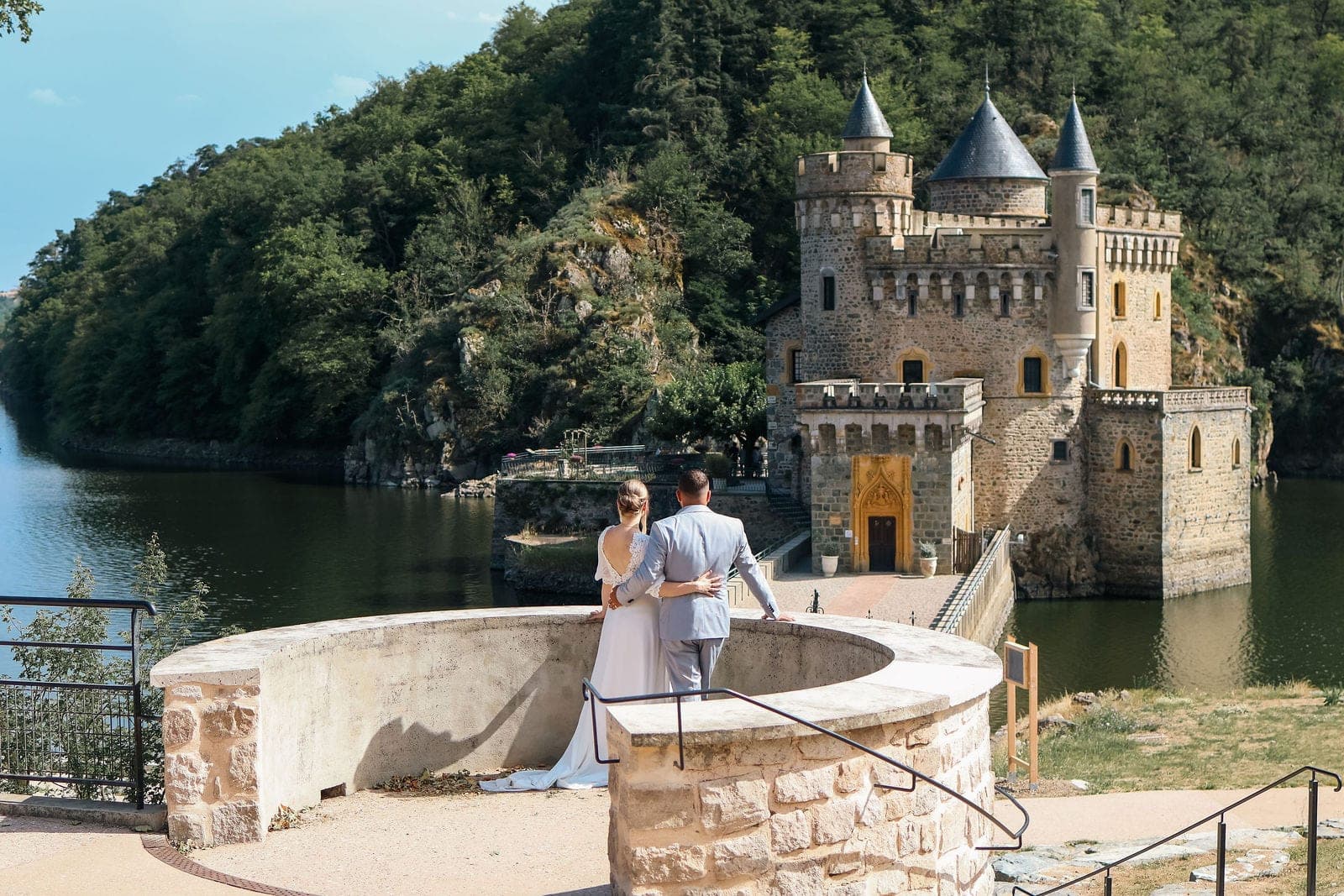 Les mariés sur la terrasse ronde du château, au bord de l’eau.