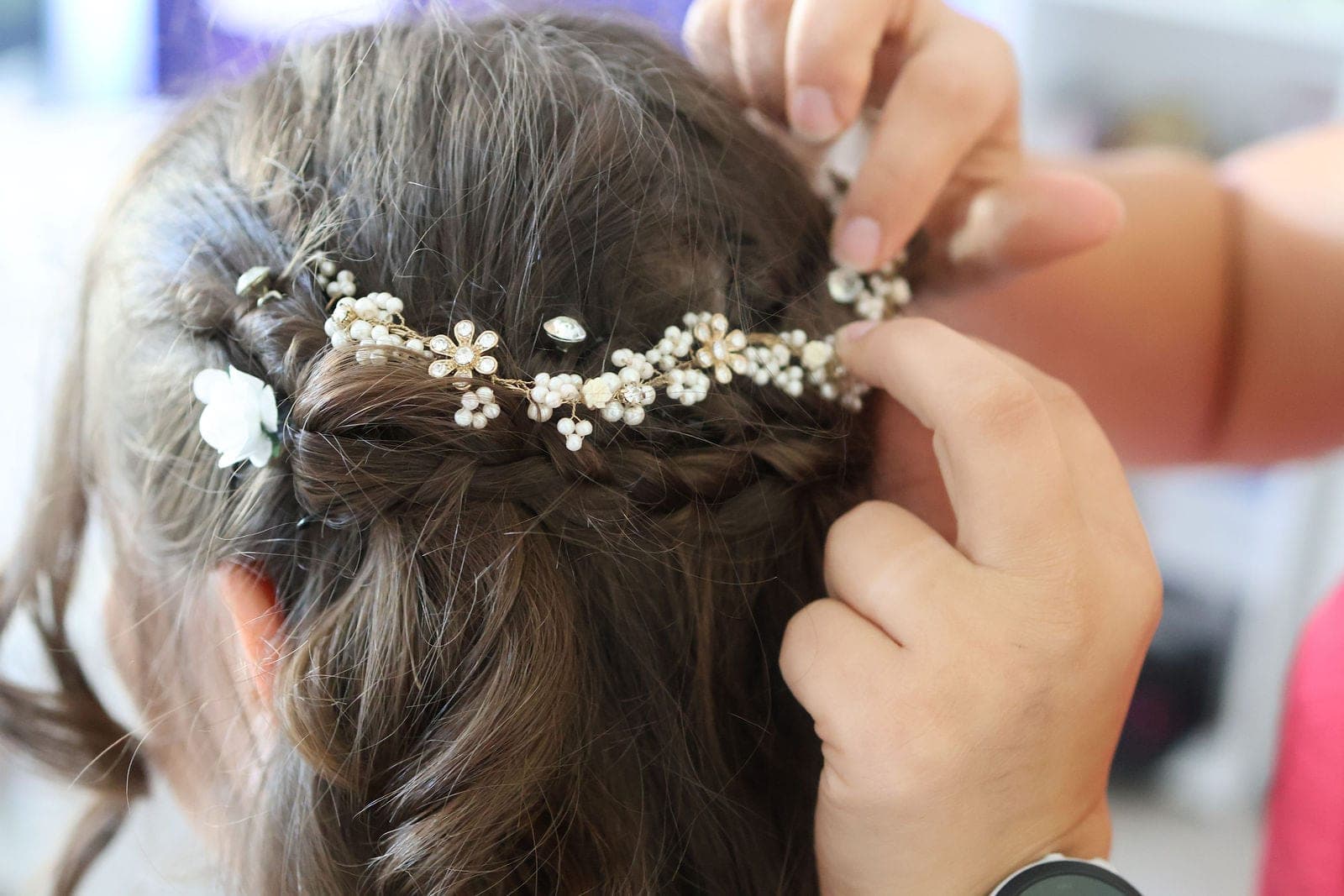 La couronne de fleurs blanches glissée dans la coiffure.