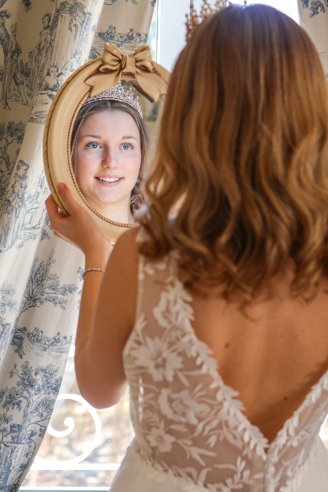 Le reflet de la mariée dans le miroir tenu à bout de bras.
