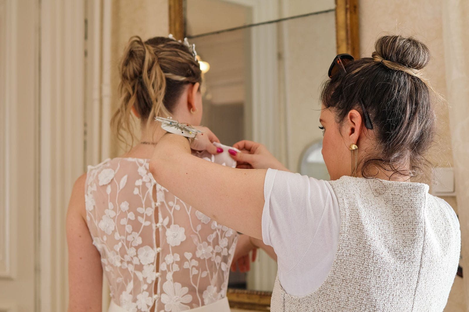 Le dos de dentelle ajusté par sa mère, devant le grand miroir.