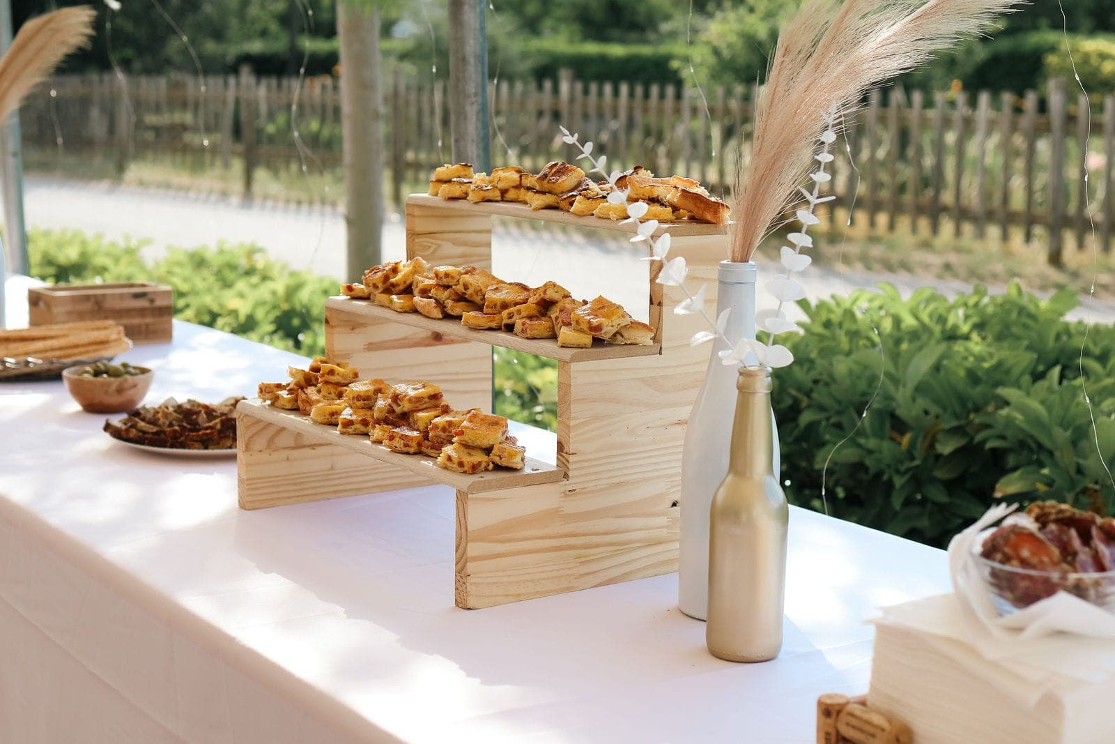Les mignardises salées présentées sur des gradins de bois.