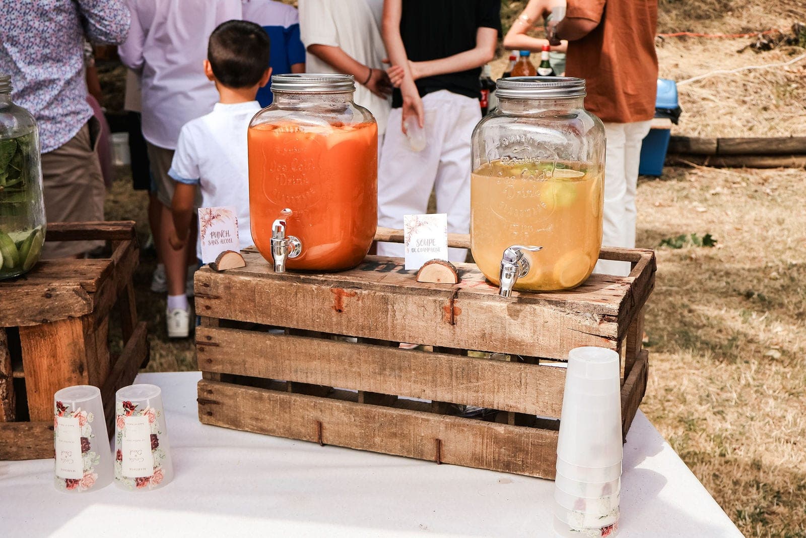 Les fontaines à limonade posées sur des caisses en bois.