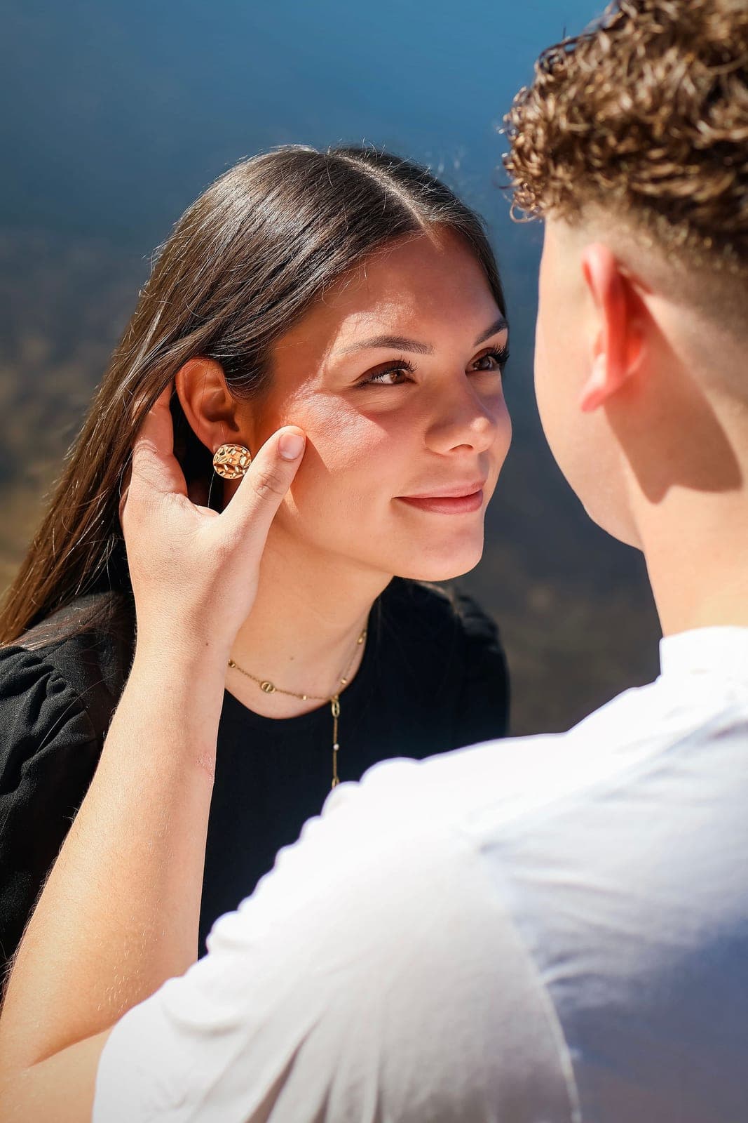 Une main posée sur la joue de l’autre, deux regards qui se croisent.