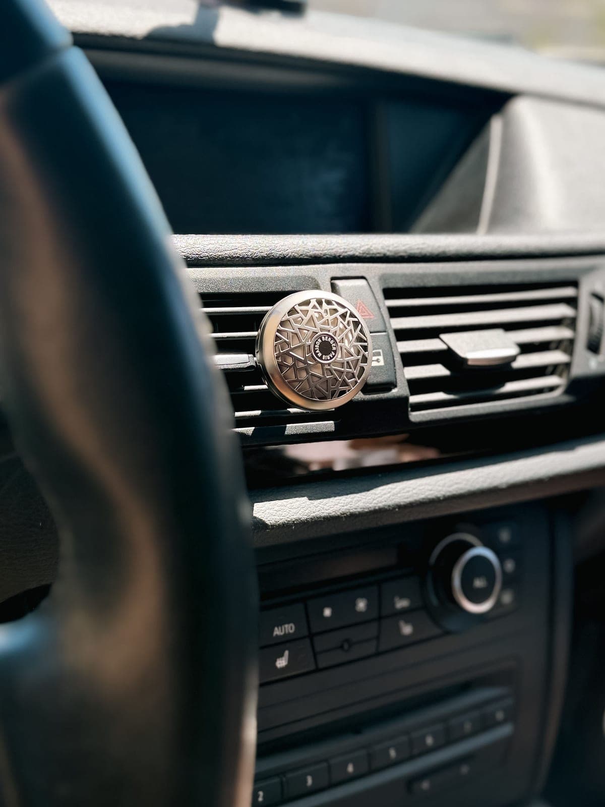 Un diffuseur de parfum fixé à la grille d’aération d’une voiture.