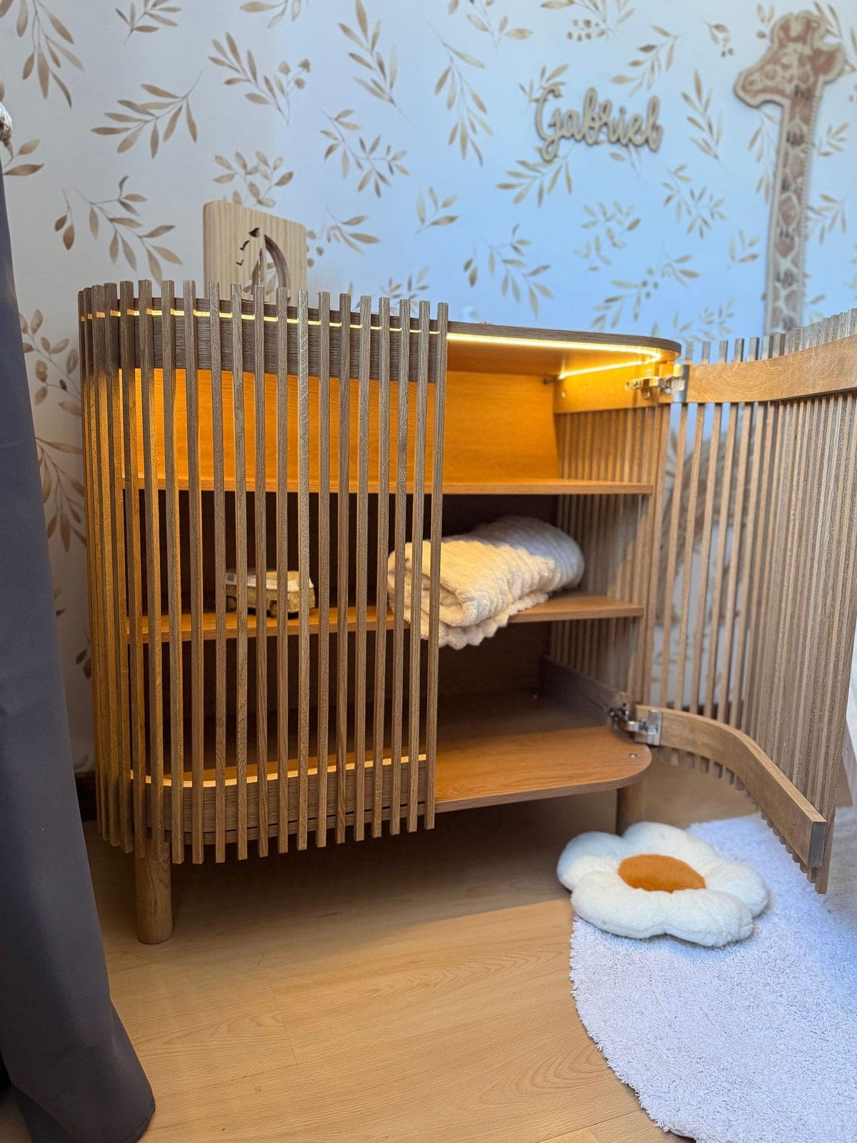 Un meuble à lattes de bois dans une chambre d’enfant.