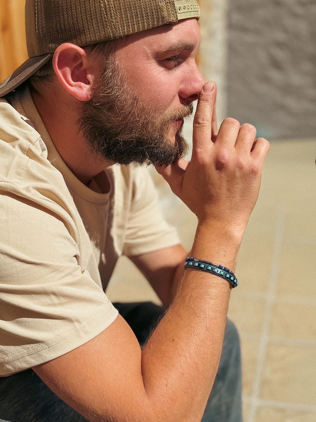 Un bracelet de perles porté au poignet, en extérieur.