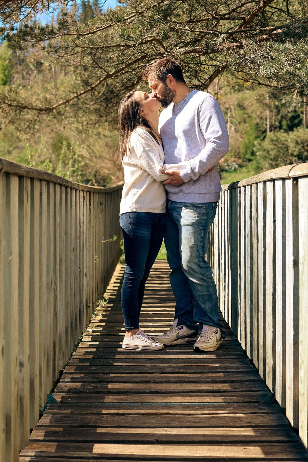 Un baiser sur une passerelle de bois, au-dessus de la rivière.