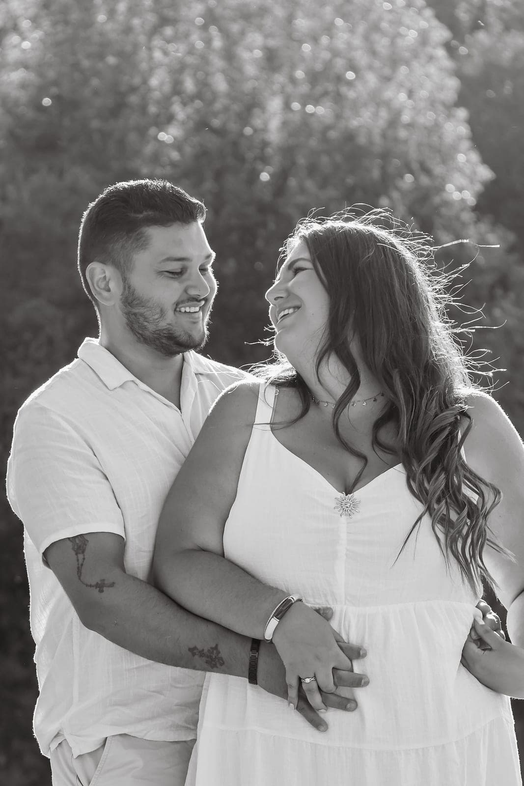 Deux sourires complices, épaule contre épaule, en noir et blanc.