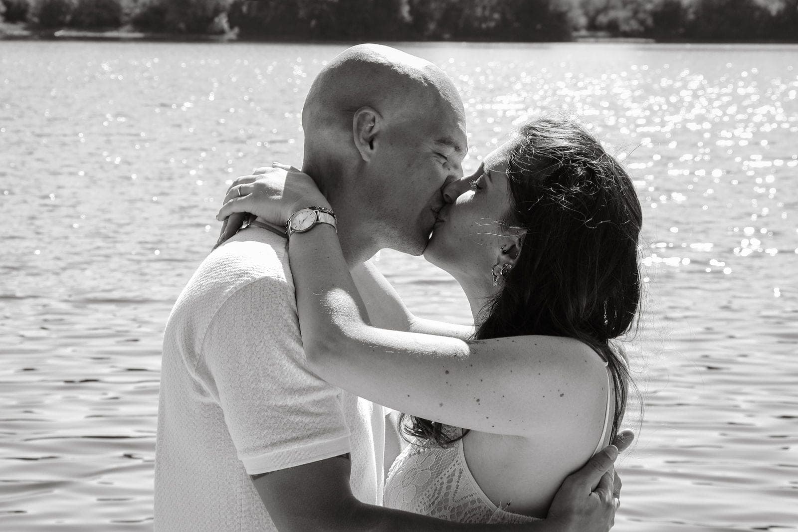 En noir et blanc, un baiser les pieds dans l’eau.