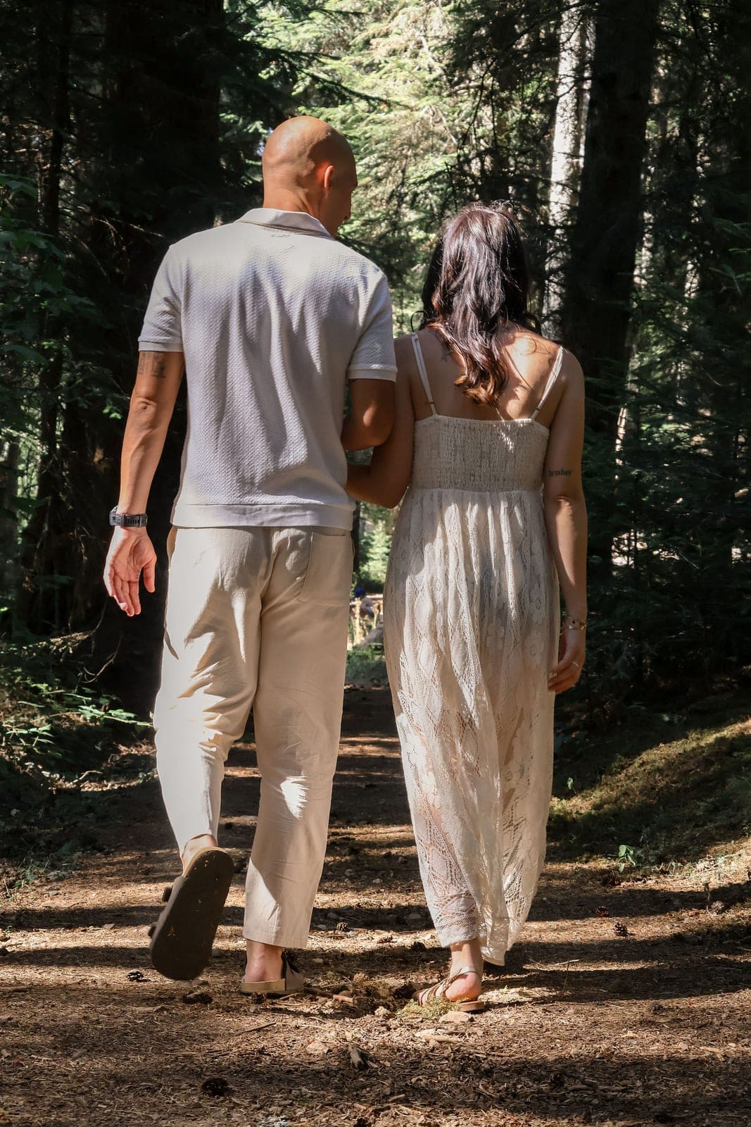 De dos, main dans la main sur le chemin forestier.