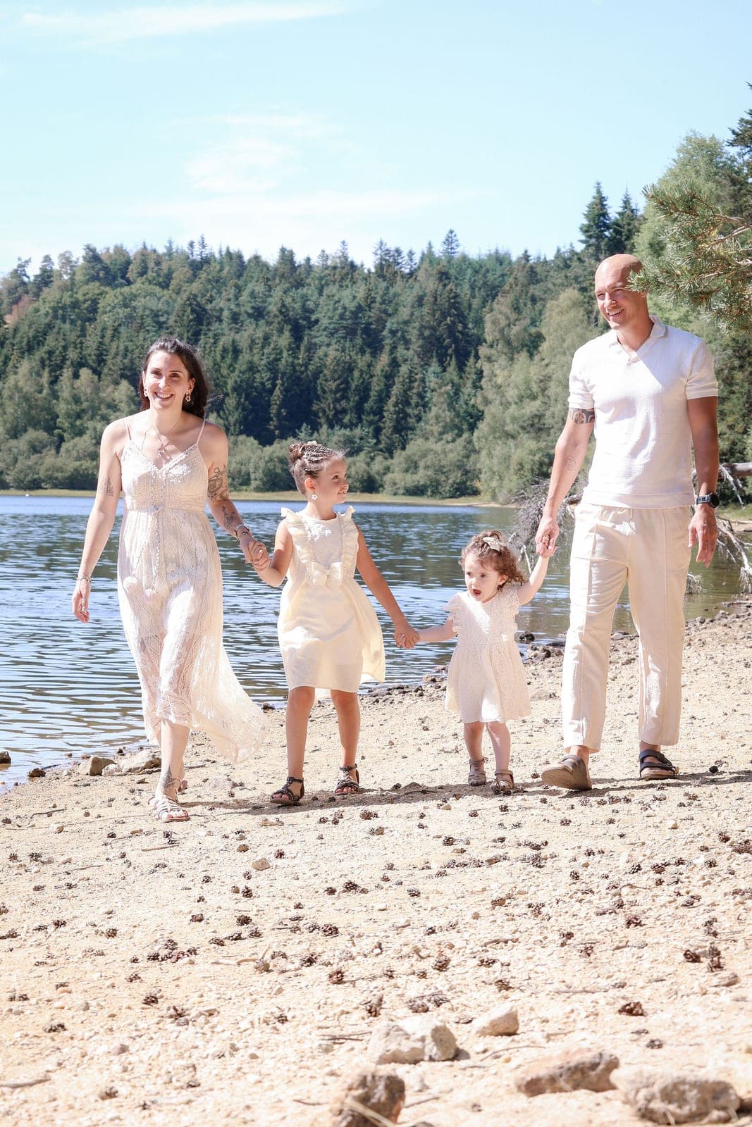 Une famille marche au bord de l’eau, les petites mains dans les grandes.
