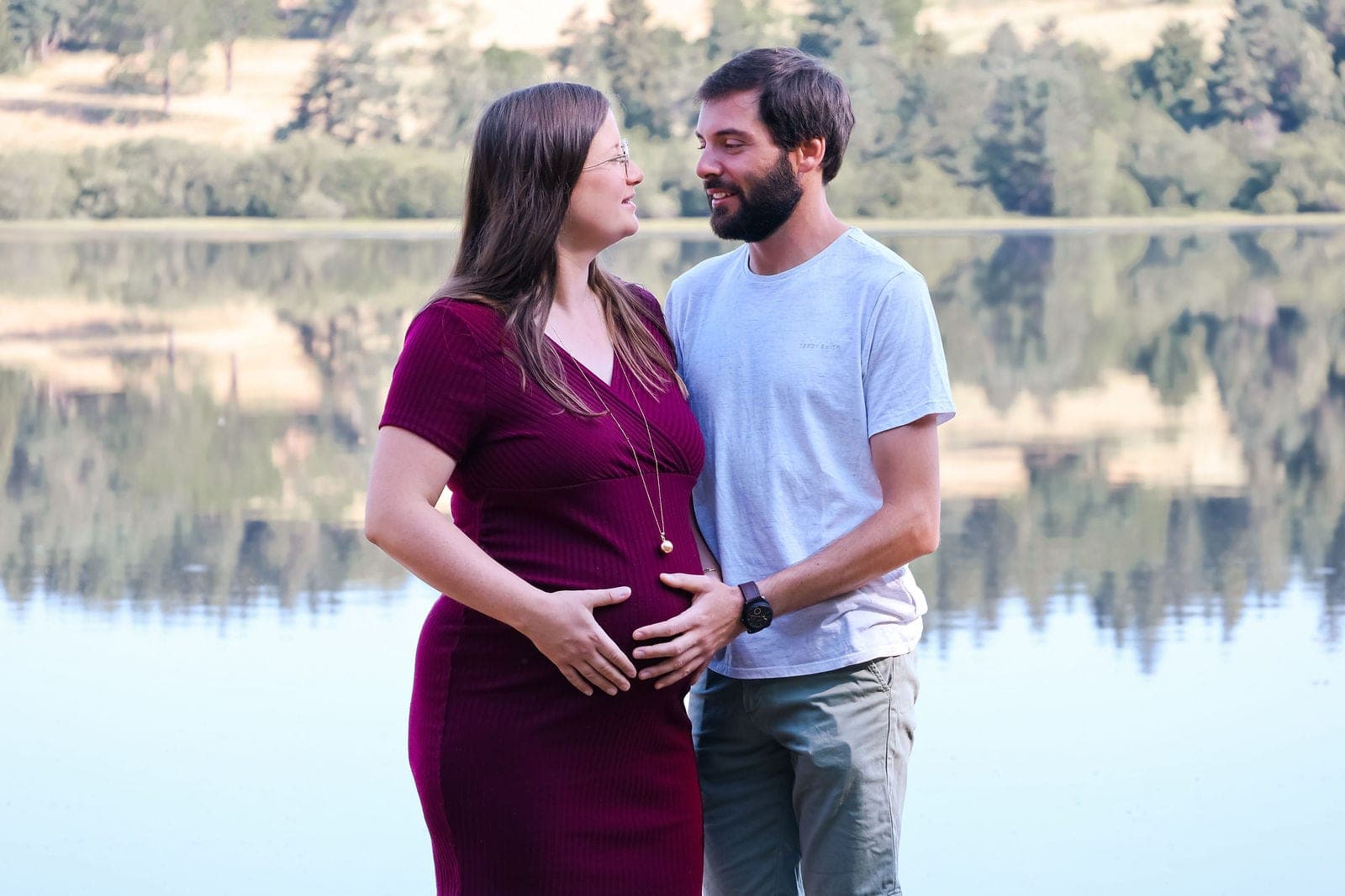Les futurs parents se regardent, au bord de l’eau.
