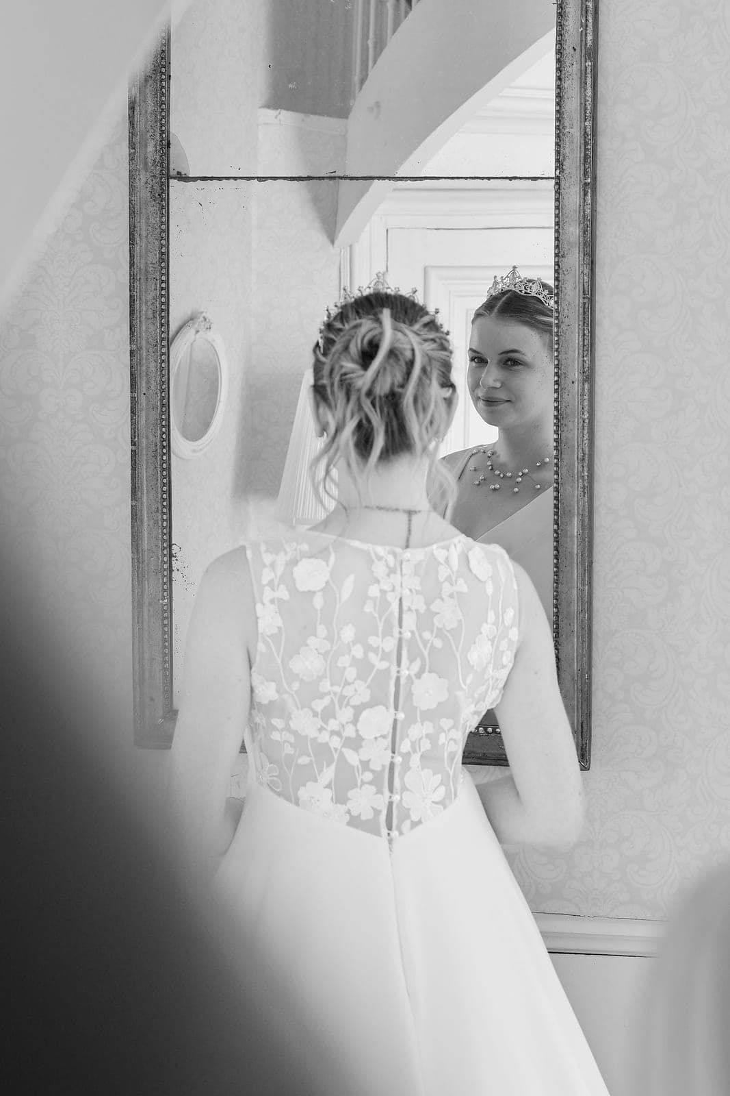 En noir et blanc, la mariée se découvre dans le miroir.