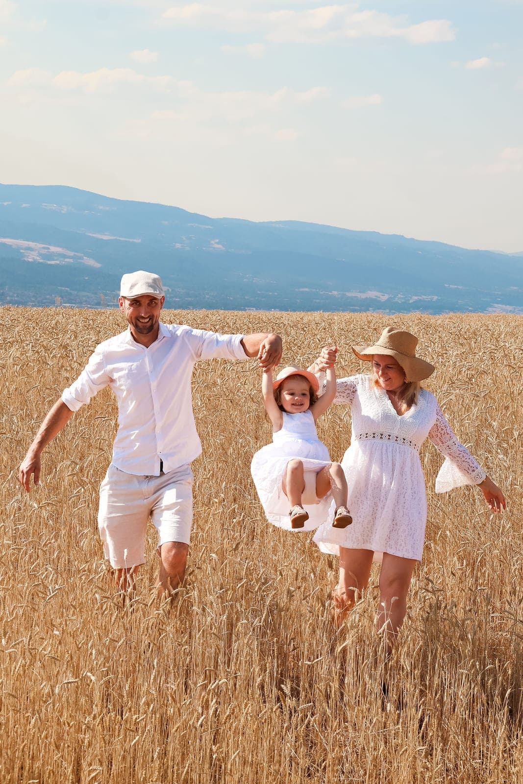 Toute la famille dans les blés, la petite qui vole entre papa et maman.