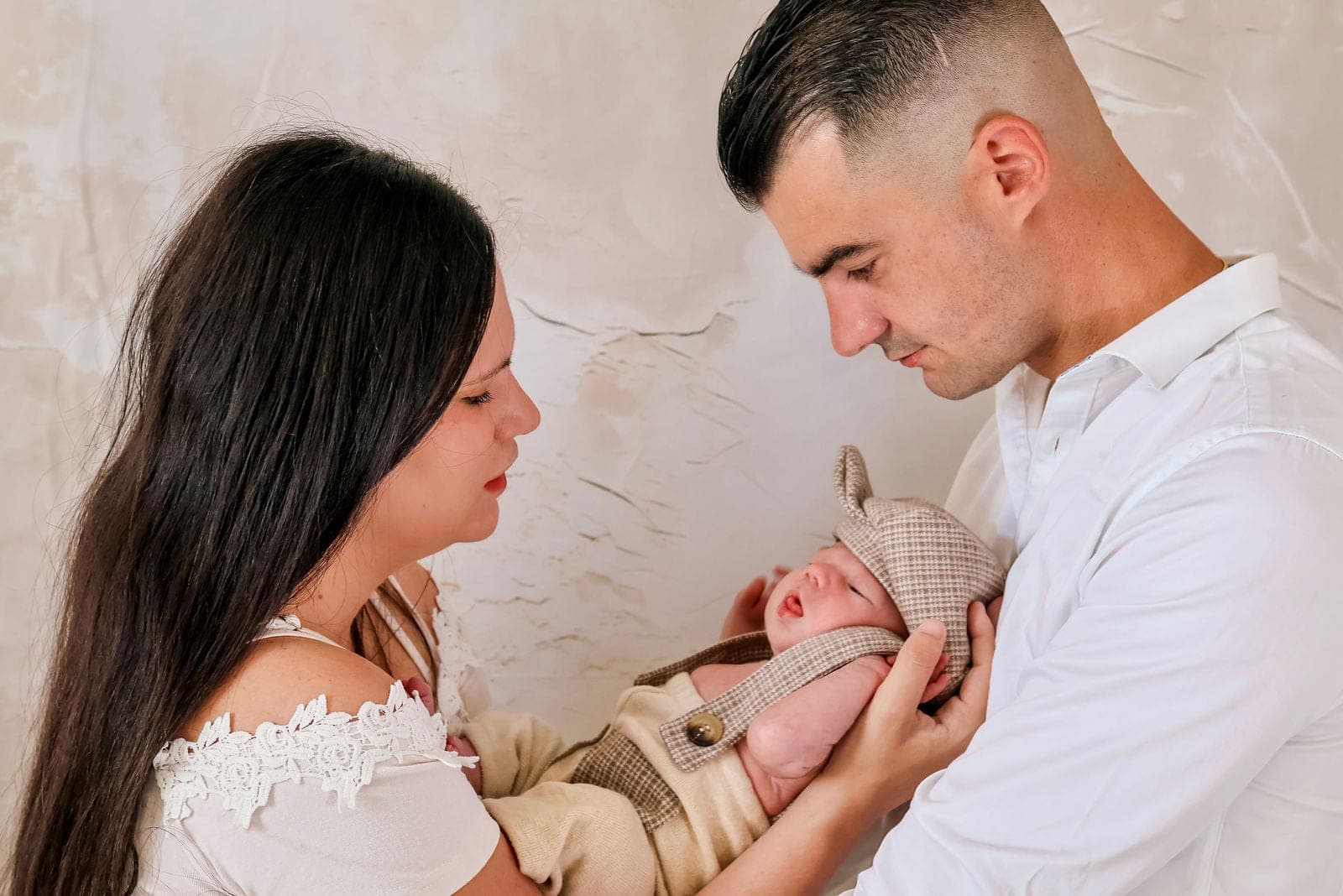 Les parents penchés sur leur nouveau-né, front contre front.