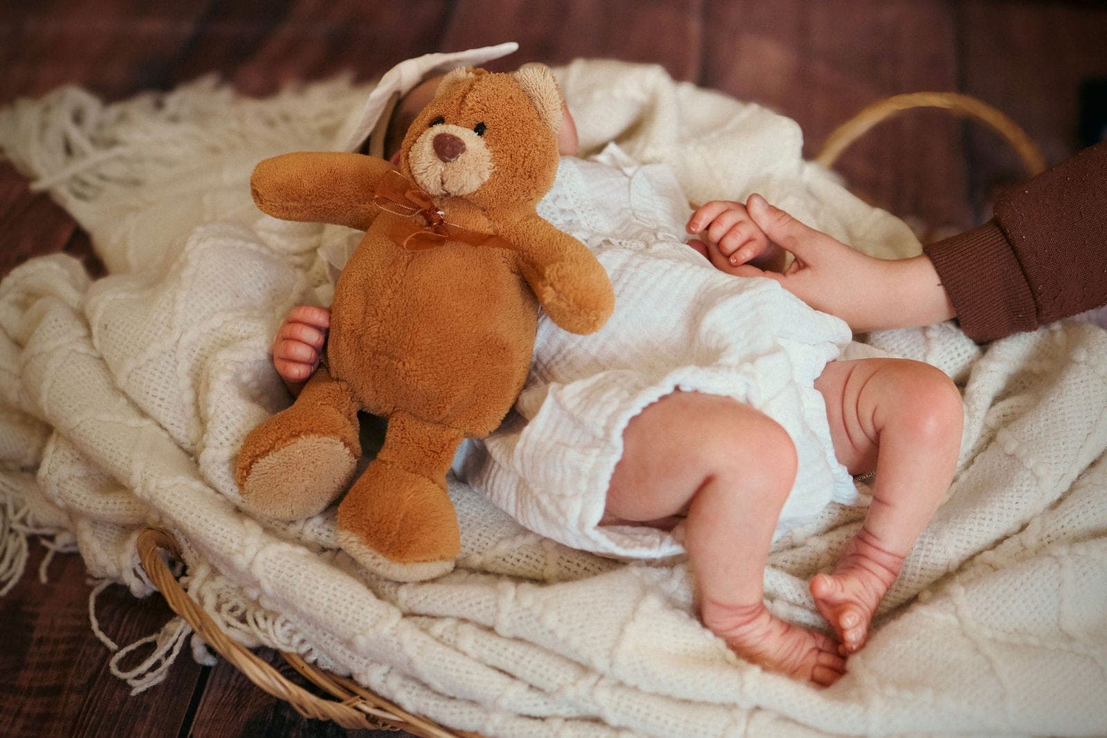 Bébé éveillé sur le dos, un petit cœur de laine posé à côté de lui.