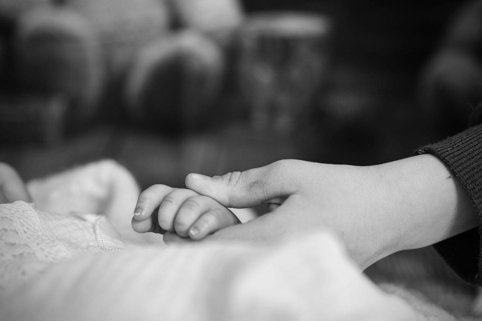 Un papa embrasse son nouveau-né blotti contre lui.
