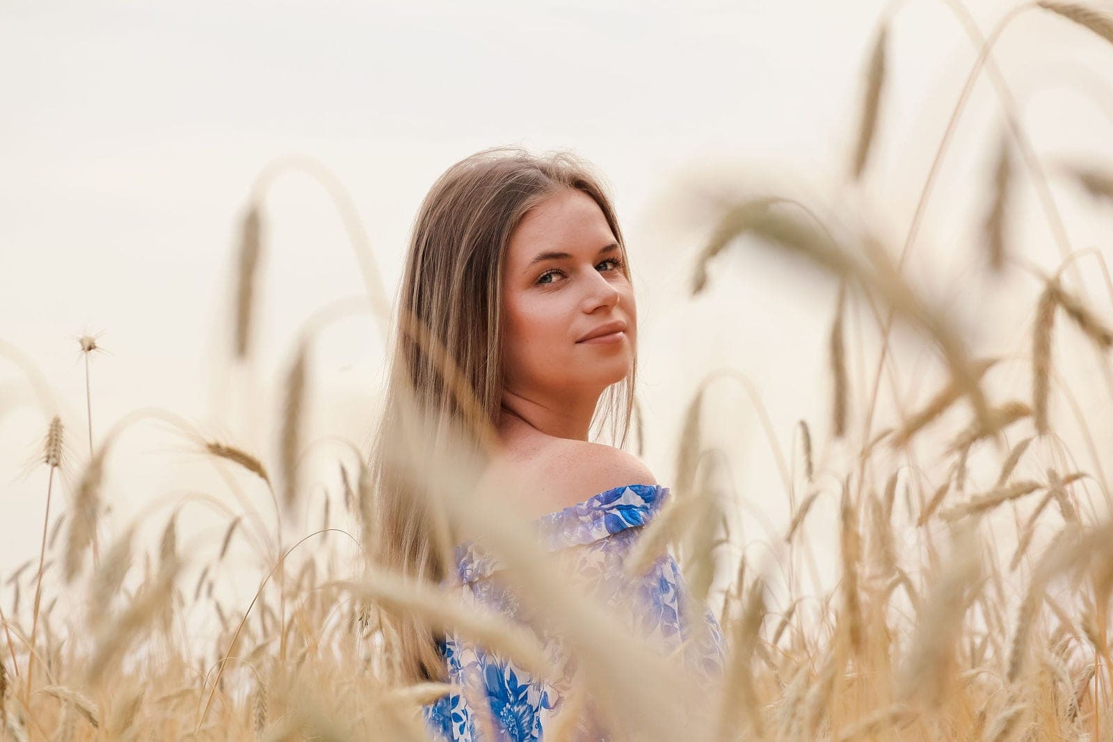 Portrait en robe bleue dans les blés dorés.