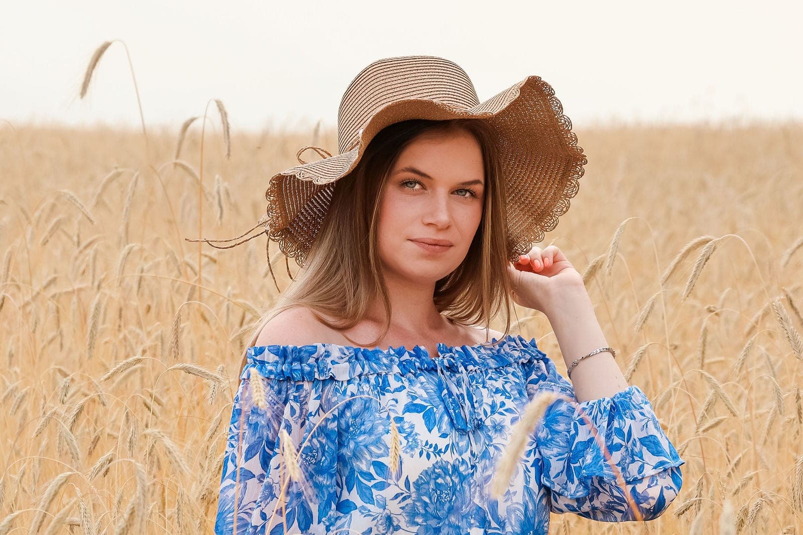 Une jeune femme au chapeau de paille, au milieu des blés.