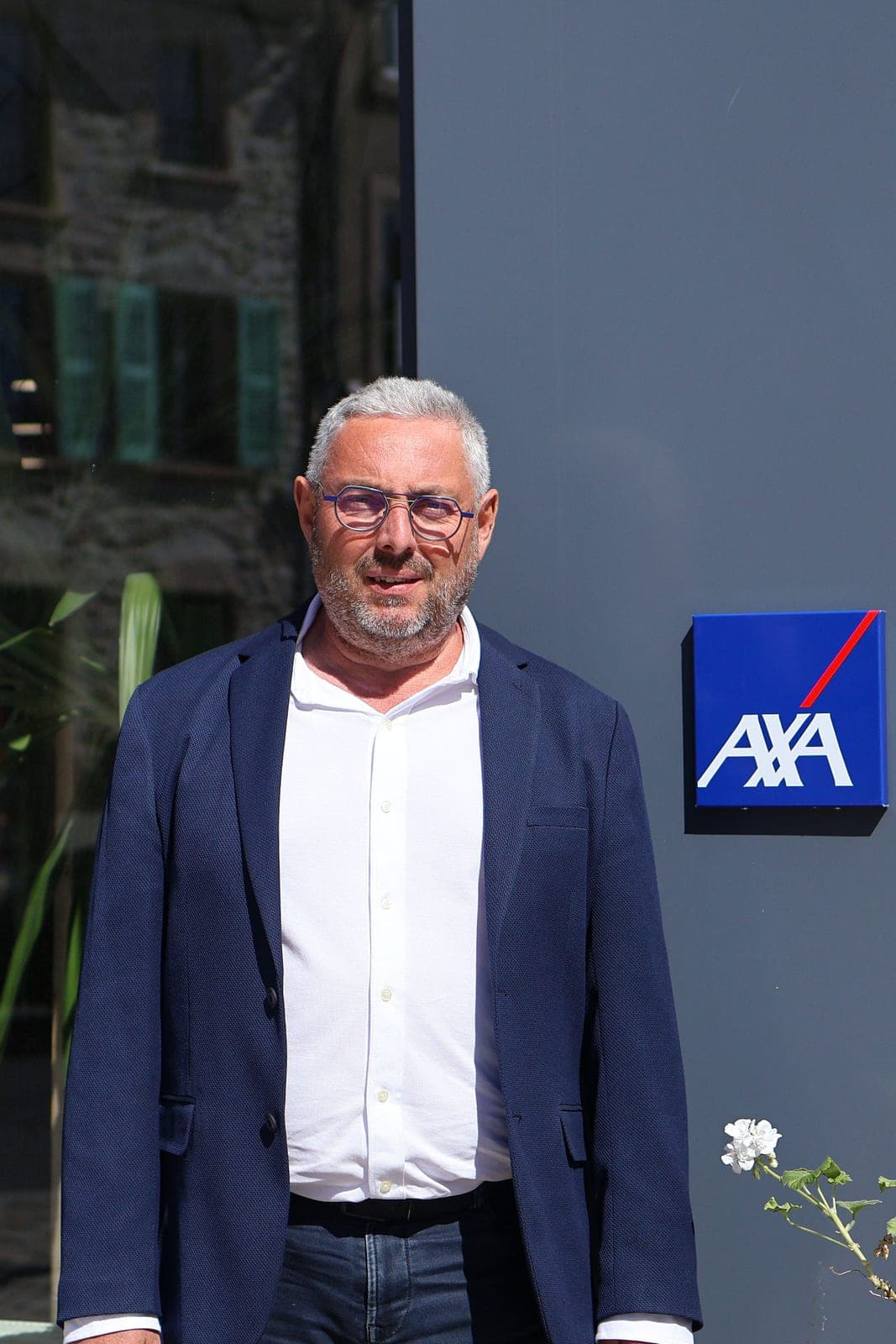 Portrait d’un dirigeant devant l’enseigne de son agence.