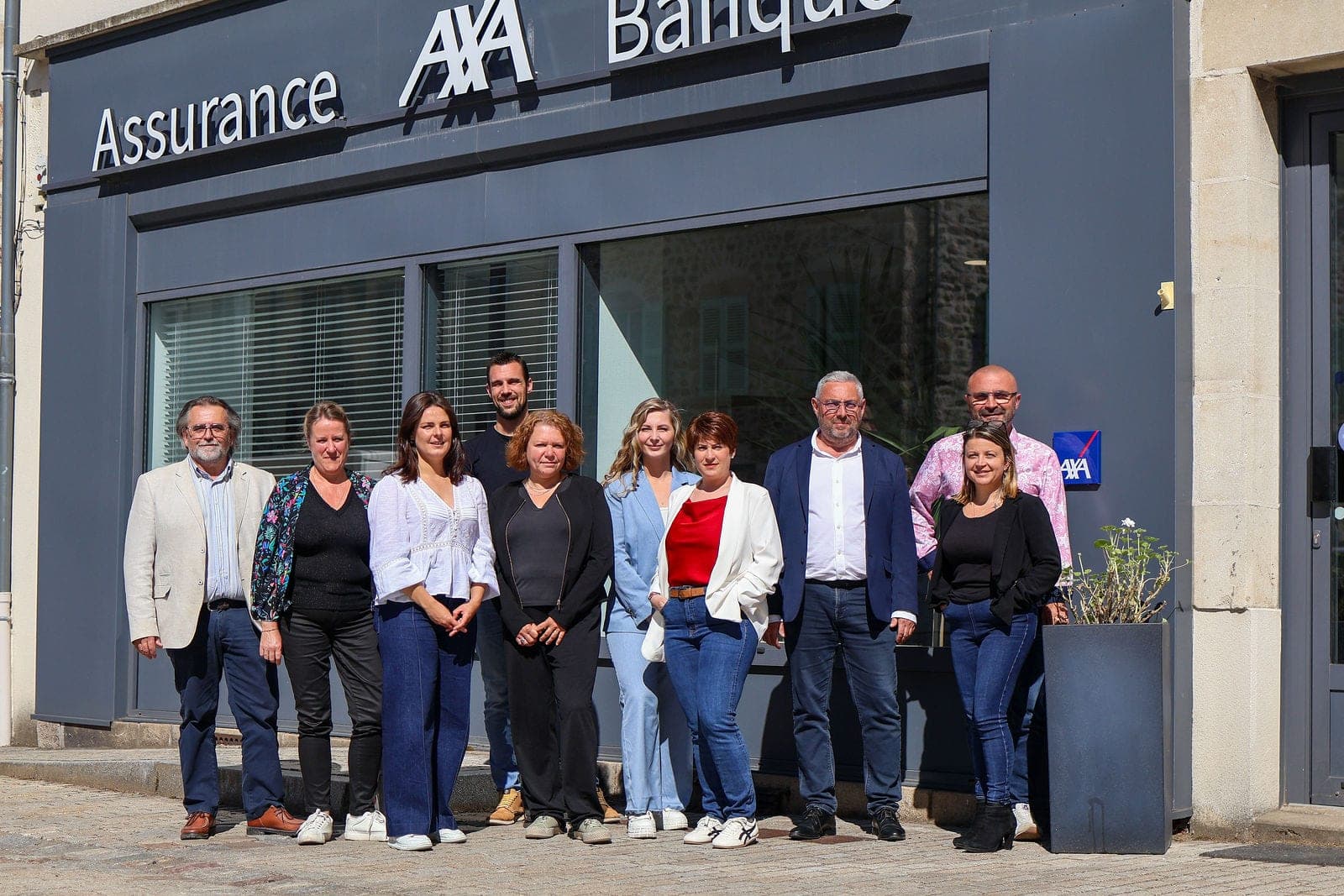 Toute l’équipe réunie devant la vitrine de l’agence.