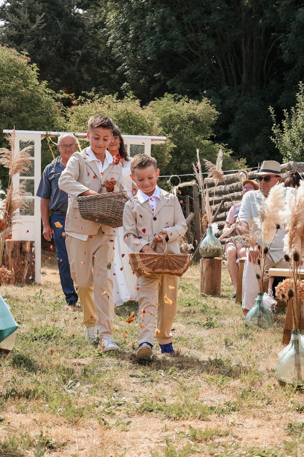 Les enfants d’honneur remontent l’allée, paniers de pétales à la main.