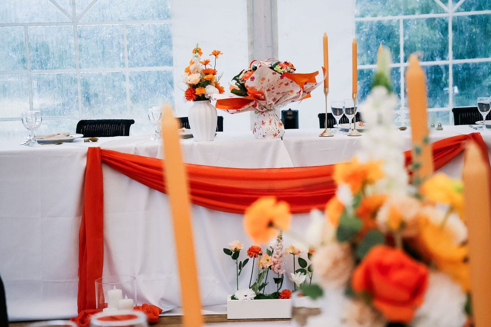 La table d’honneur habillée d’orange et de fleurs.